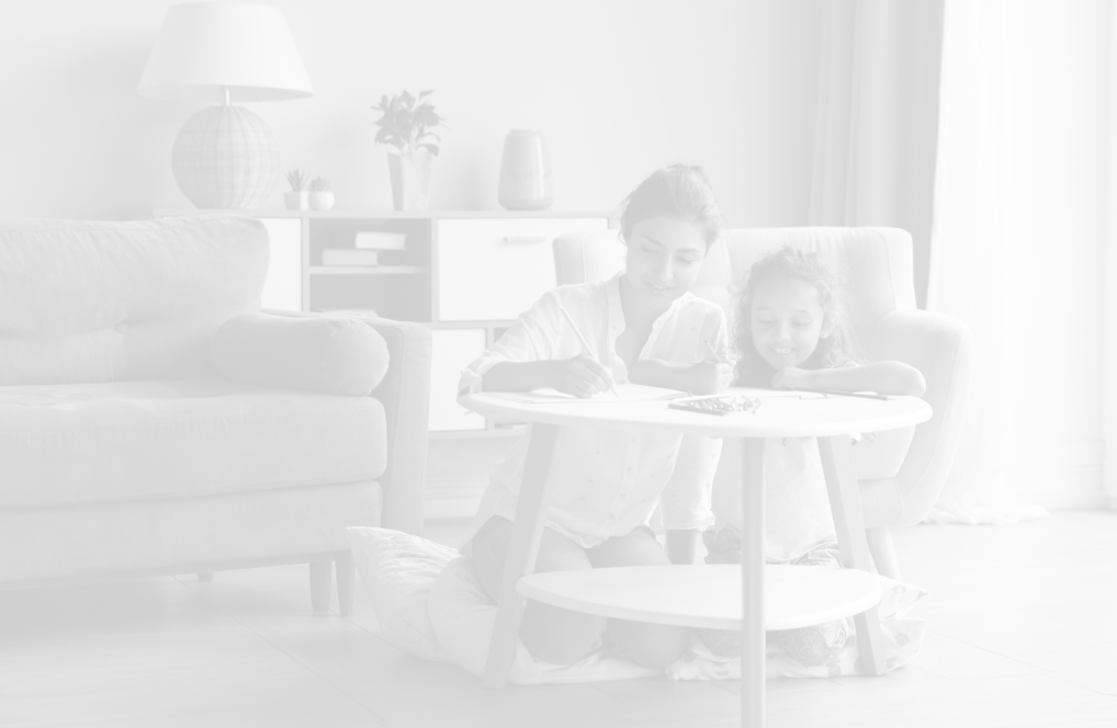 A mother and daughter in their living room colouring while sitting at their coffee table.