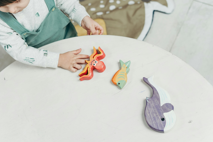 Toddler engaging with Montessori wooden animal toys at OC Toddler School daycare in Irvine CA