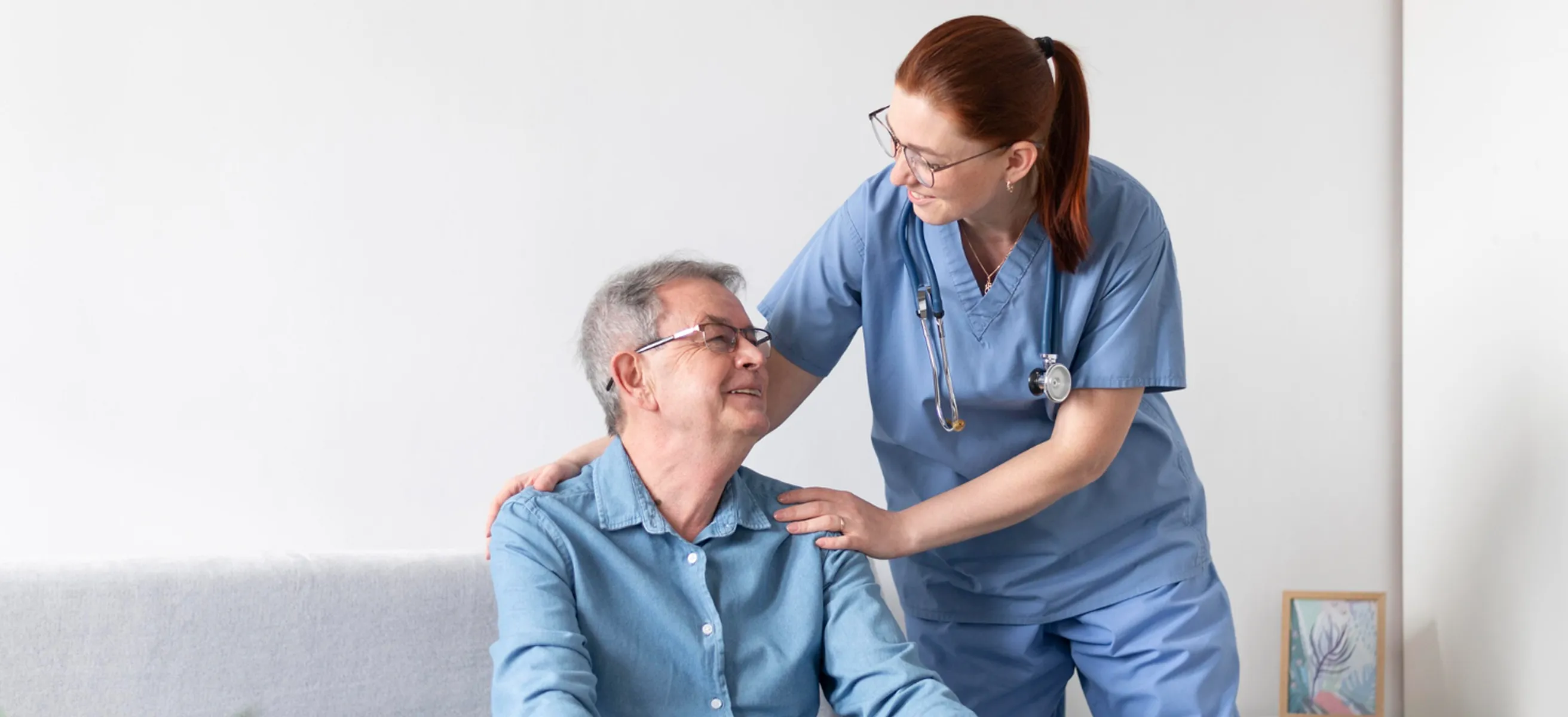 A nurse helping a man in a wheelchair.