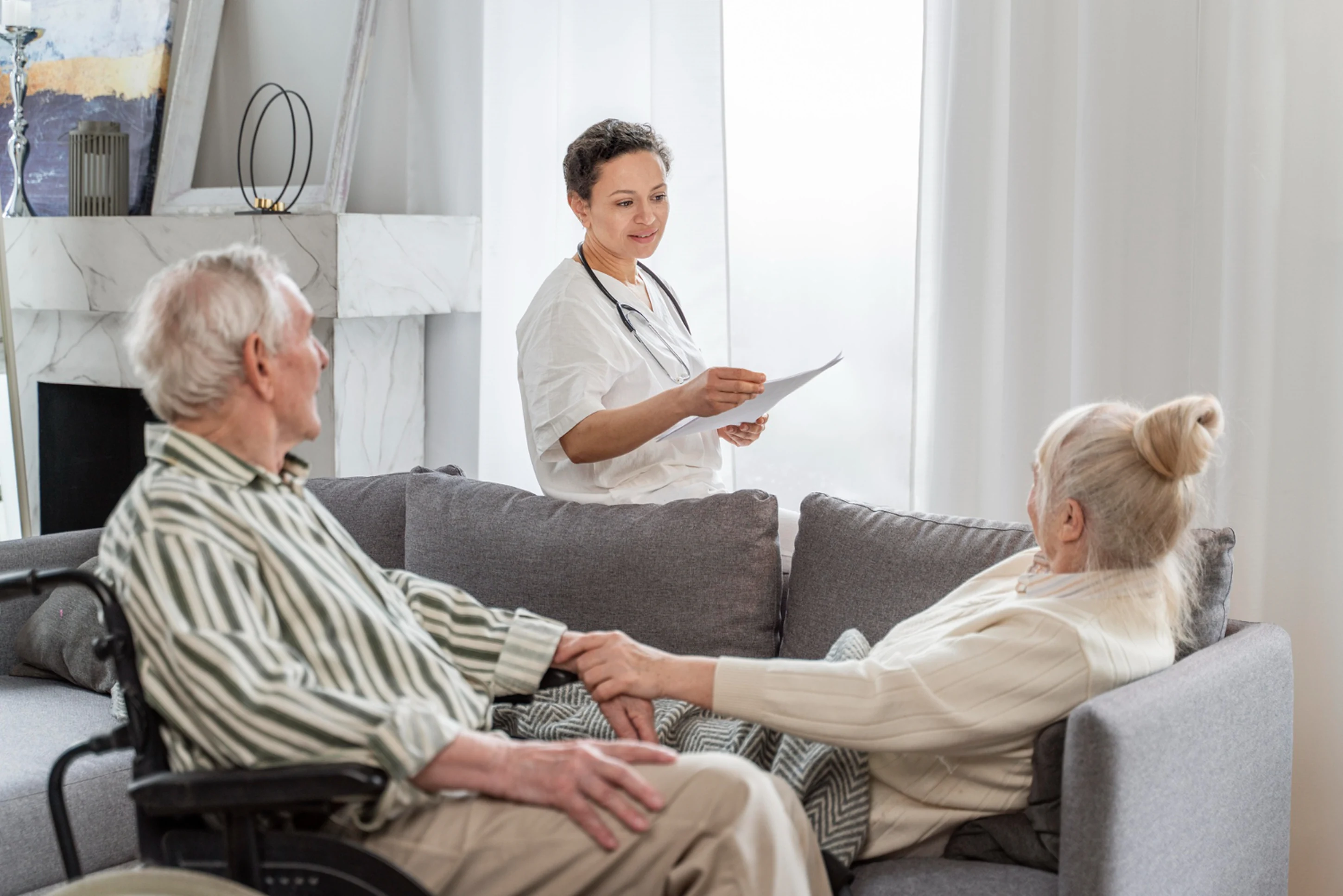 A nurse is talking to a patient on a couch.