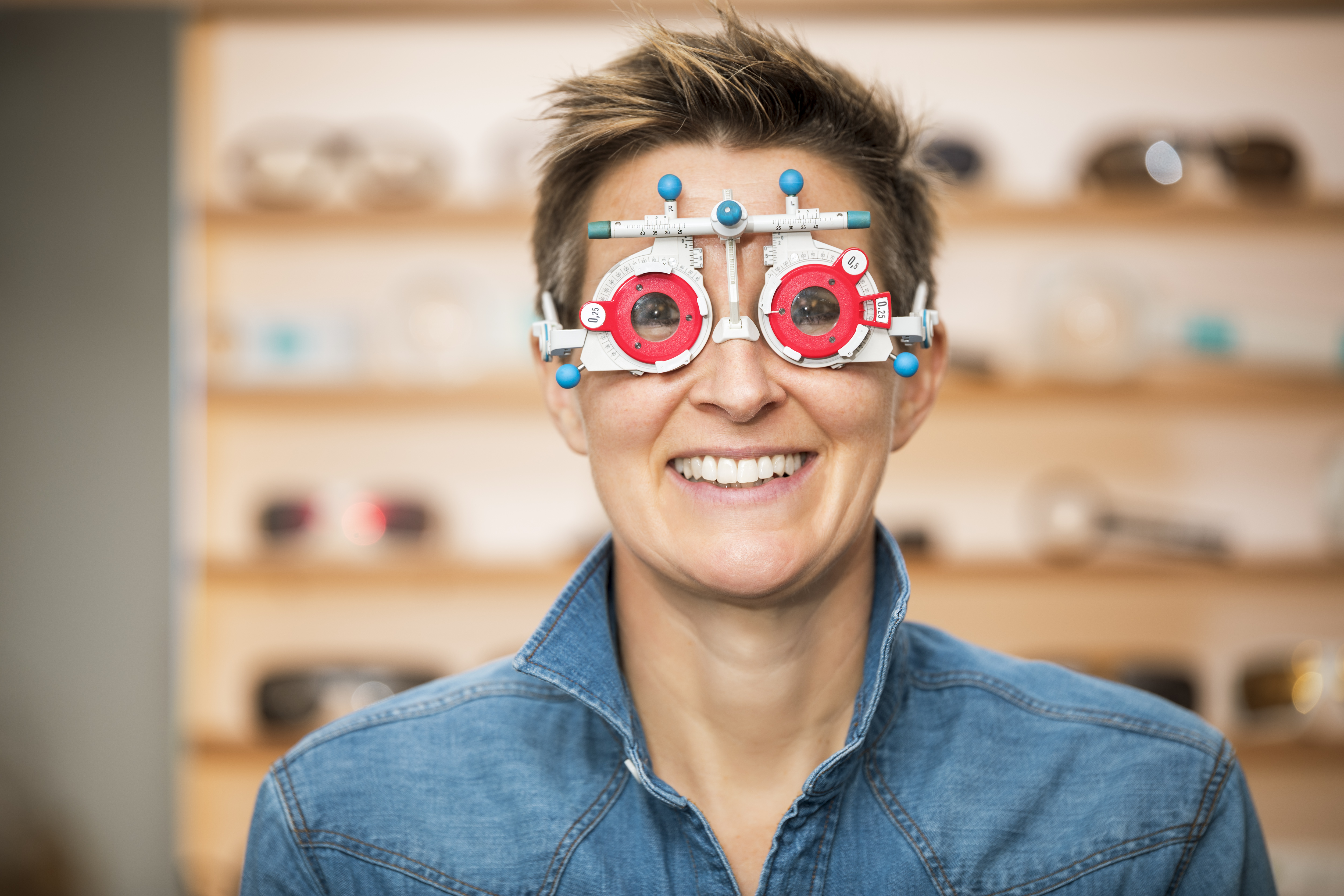 Smiling person wearing optometry device for eye examination