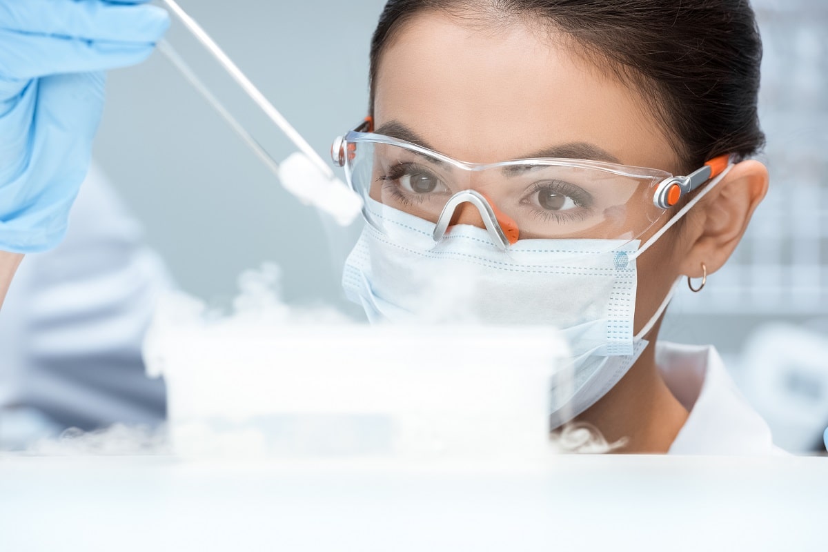 Medical professional with protective mask and safety glasses in laboratory