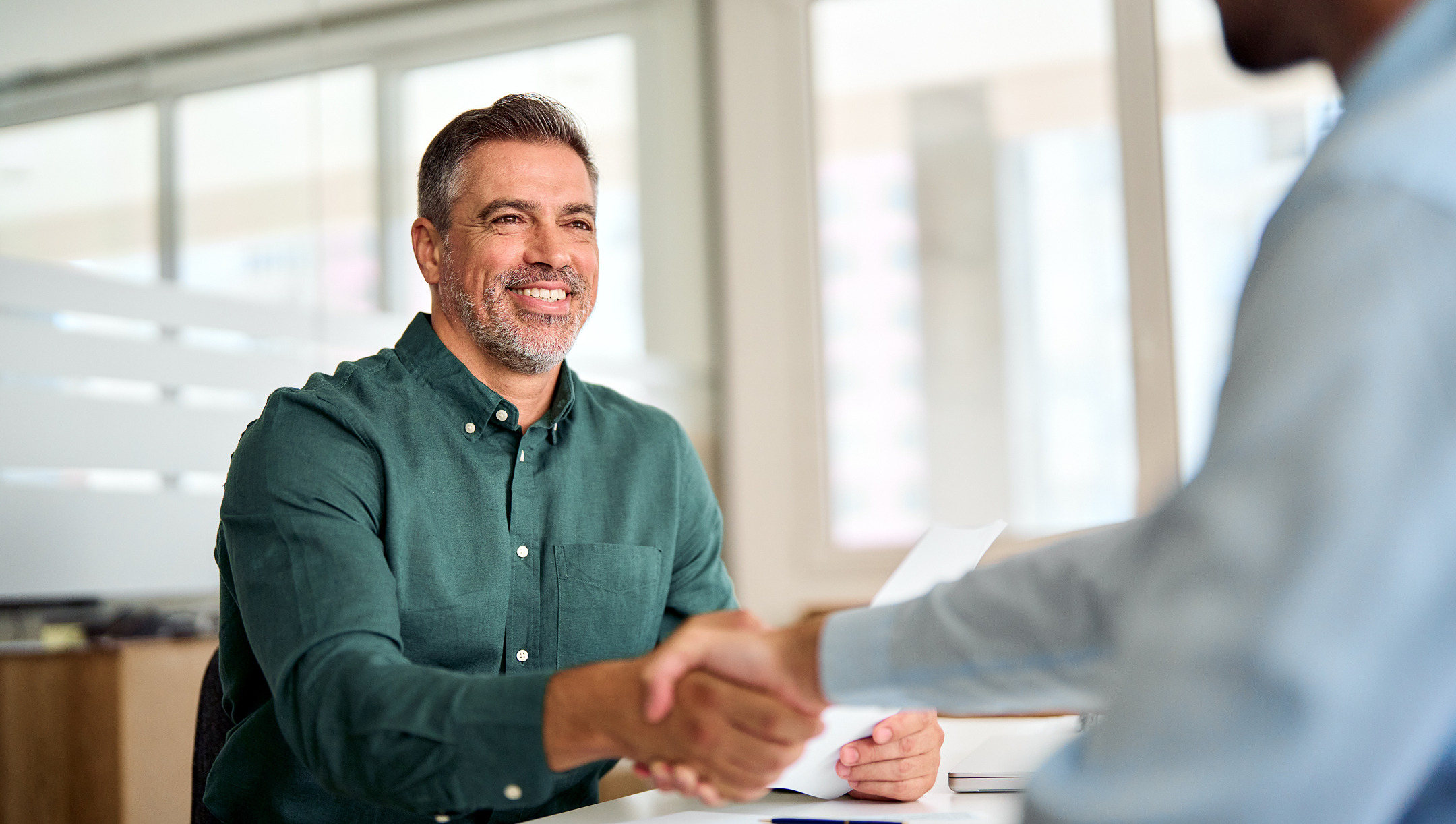 A carrier sales rep shaking hands with a broker partner