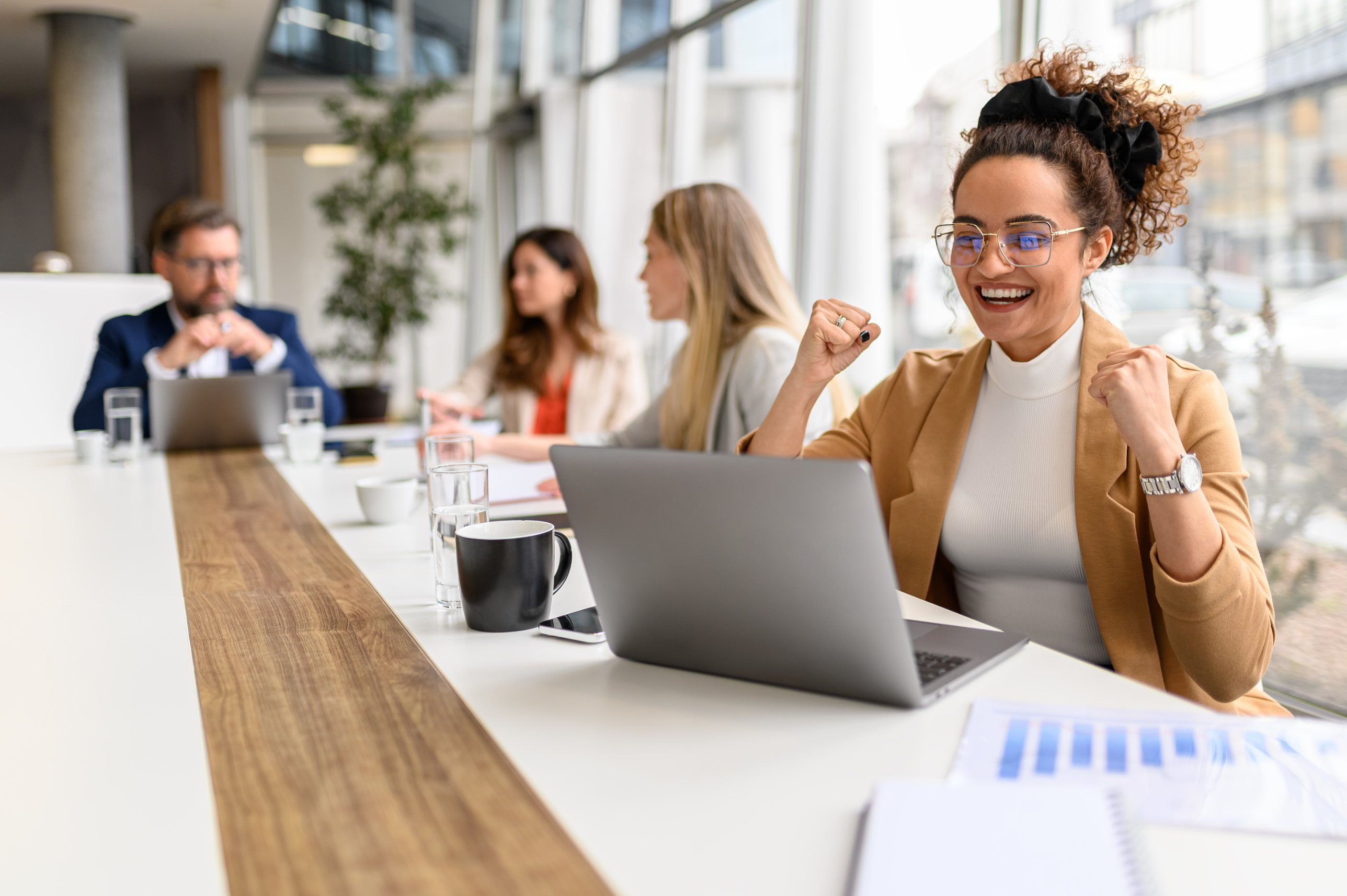 A sales rep celebrating at her laptop
