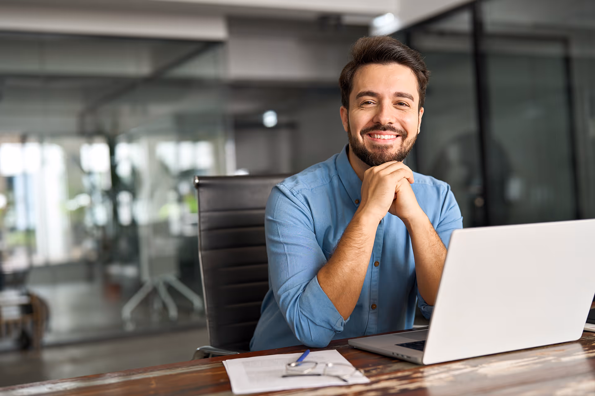 A man sat in an office smiling