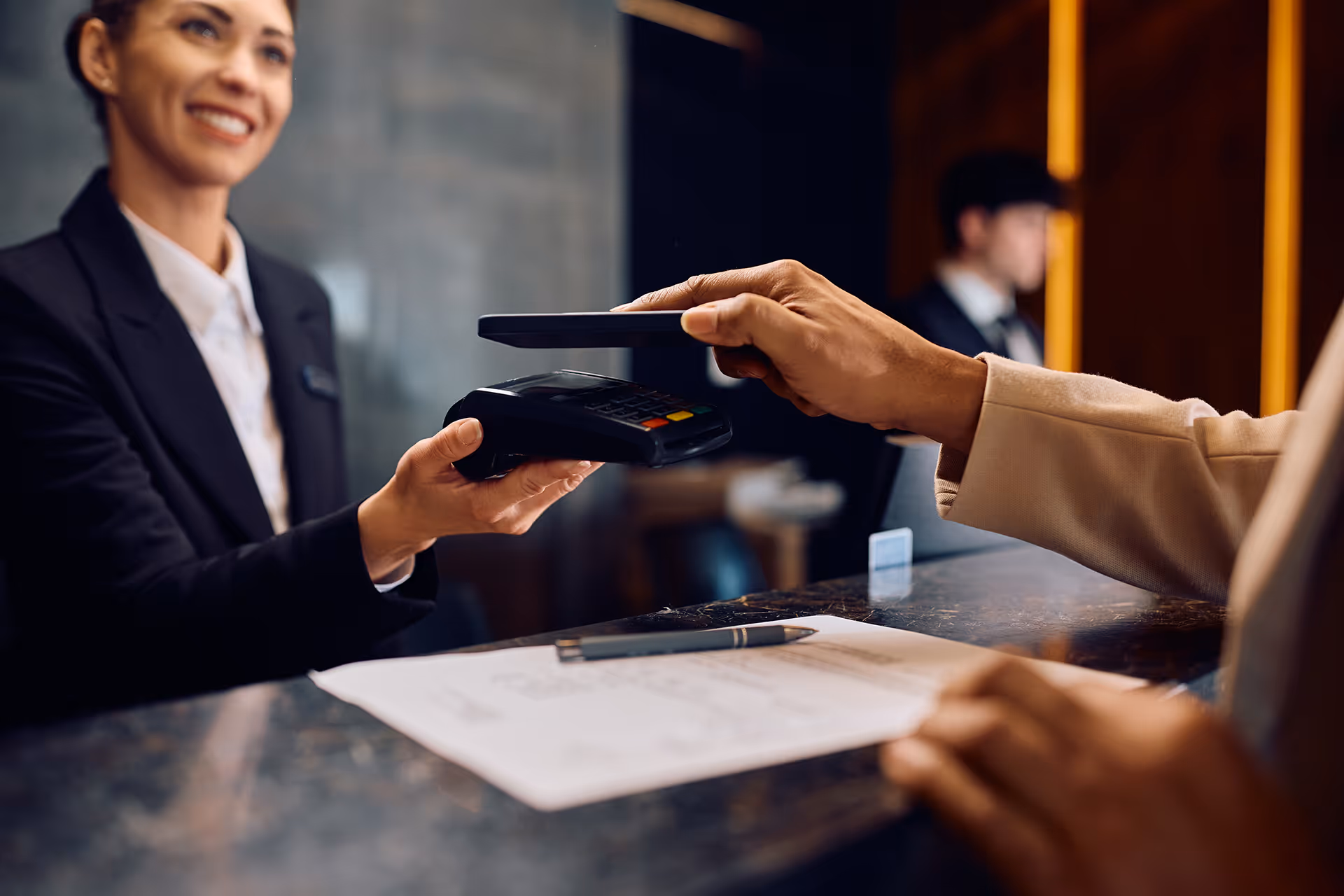 Hotel worker taking contactless phone payment — representing chargeback management