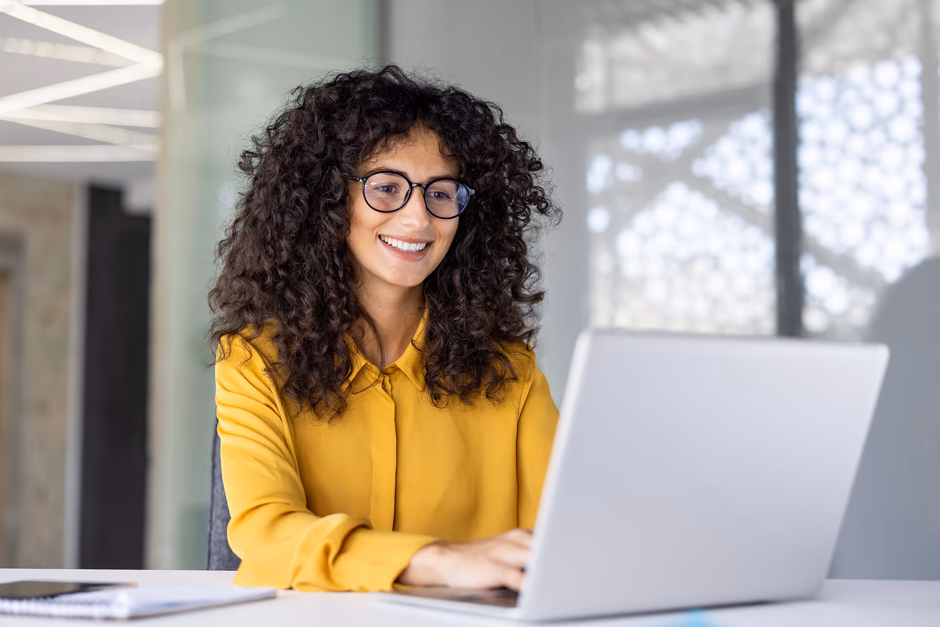 A woman sat at a laptop managing costs