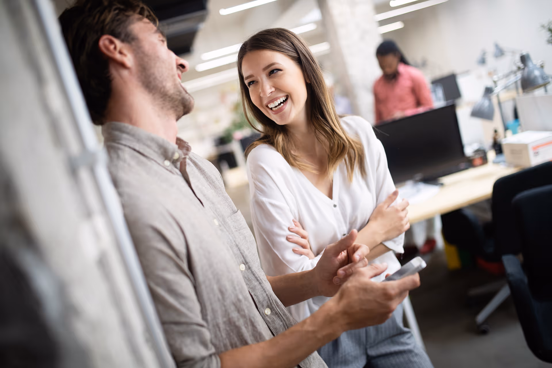 A couple laughing together in an office