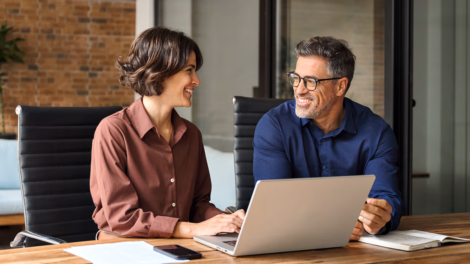 Two people chatting together over a laptop