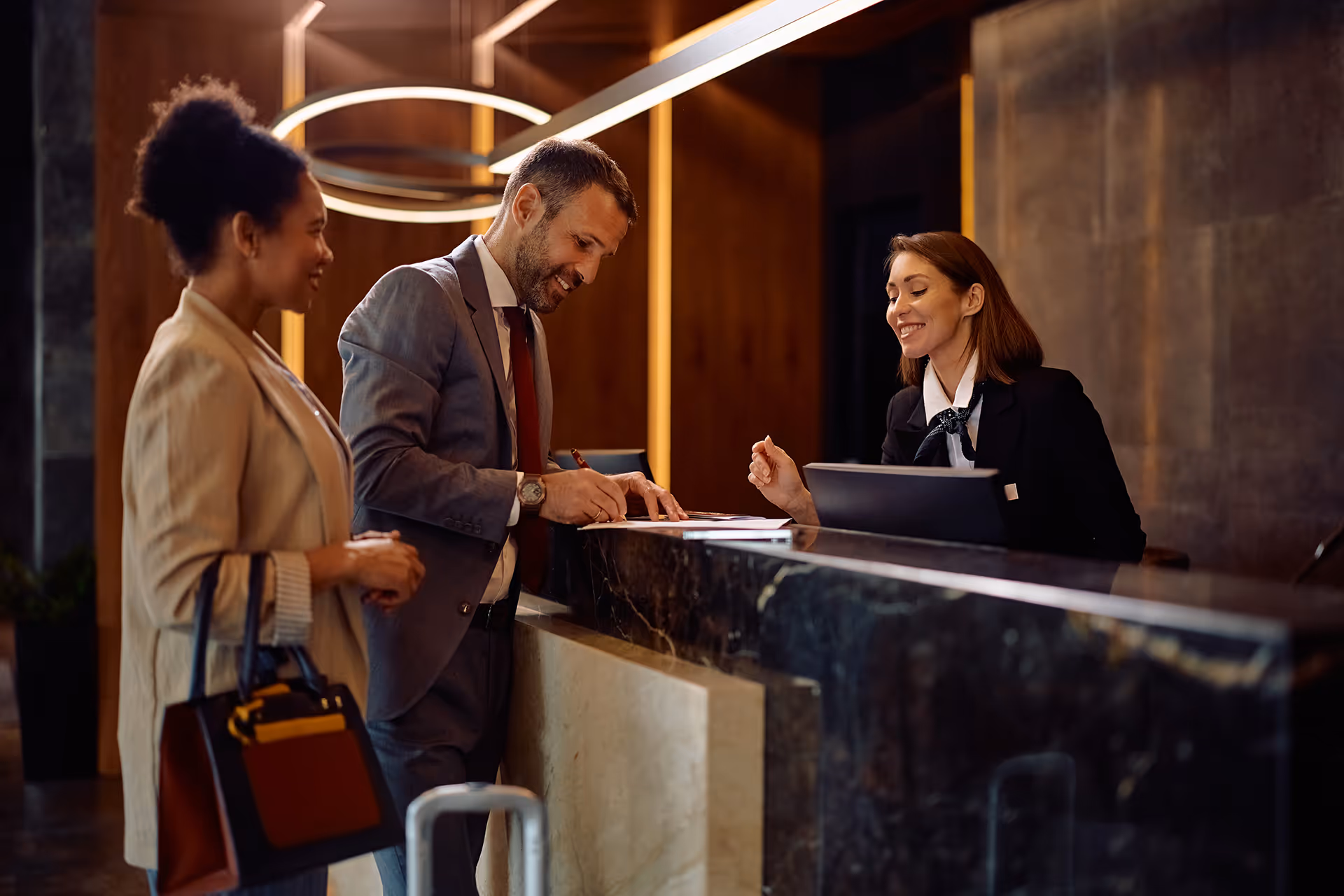People checking in at a hotel — representing global merchant accounts