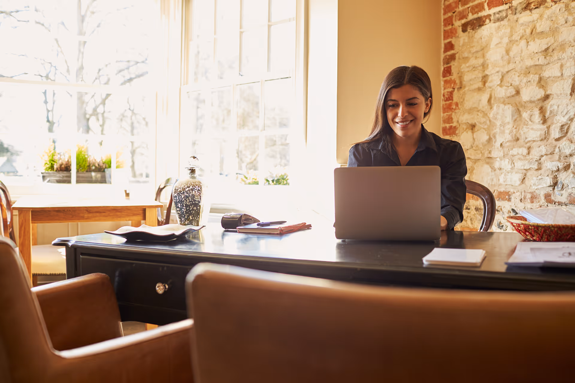 Woman working on her laptop in a bright office room