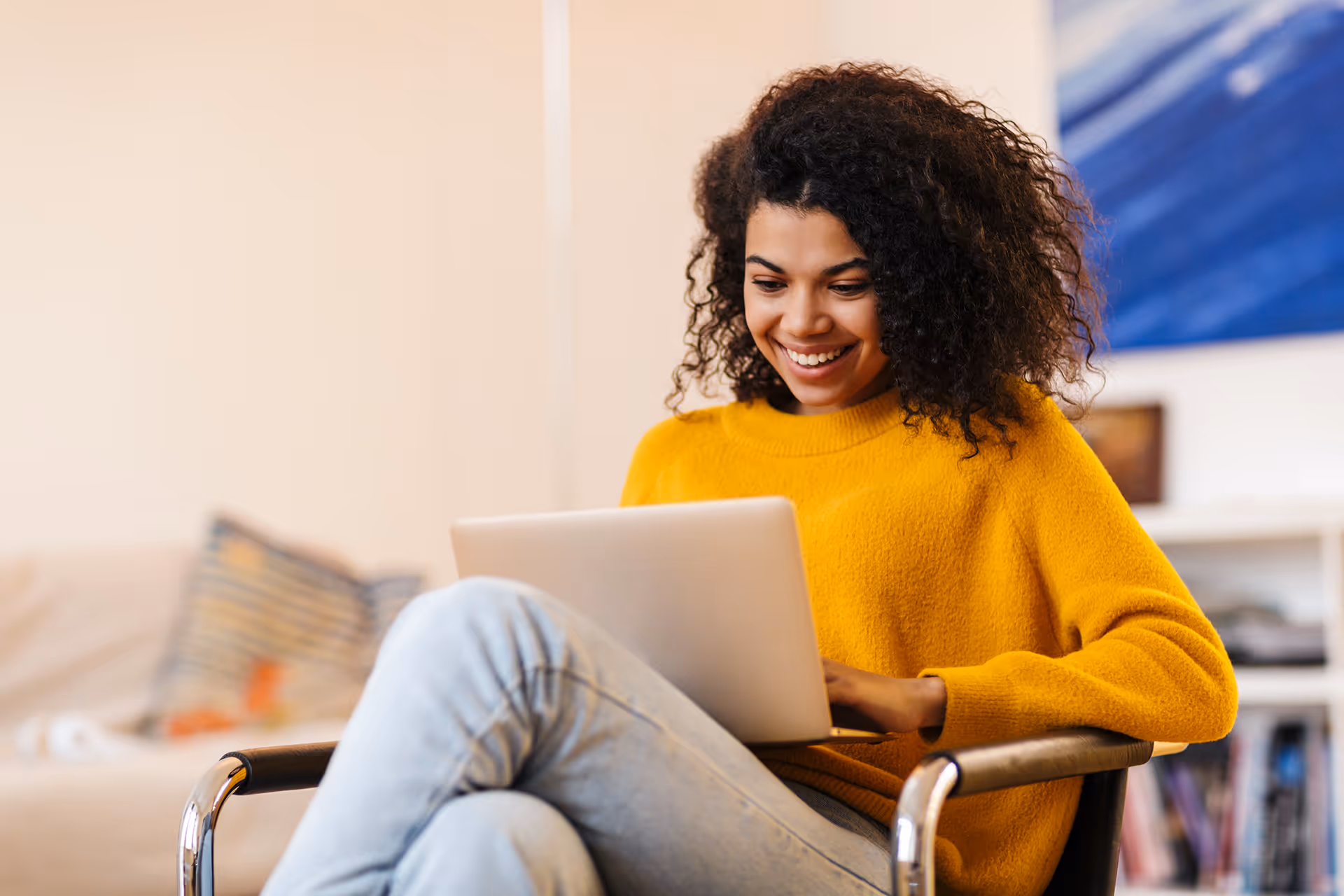 Woman sat in a chair working on a laptop