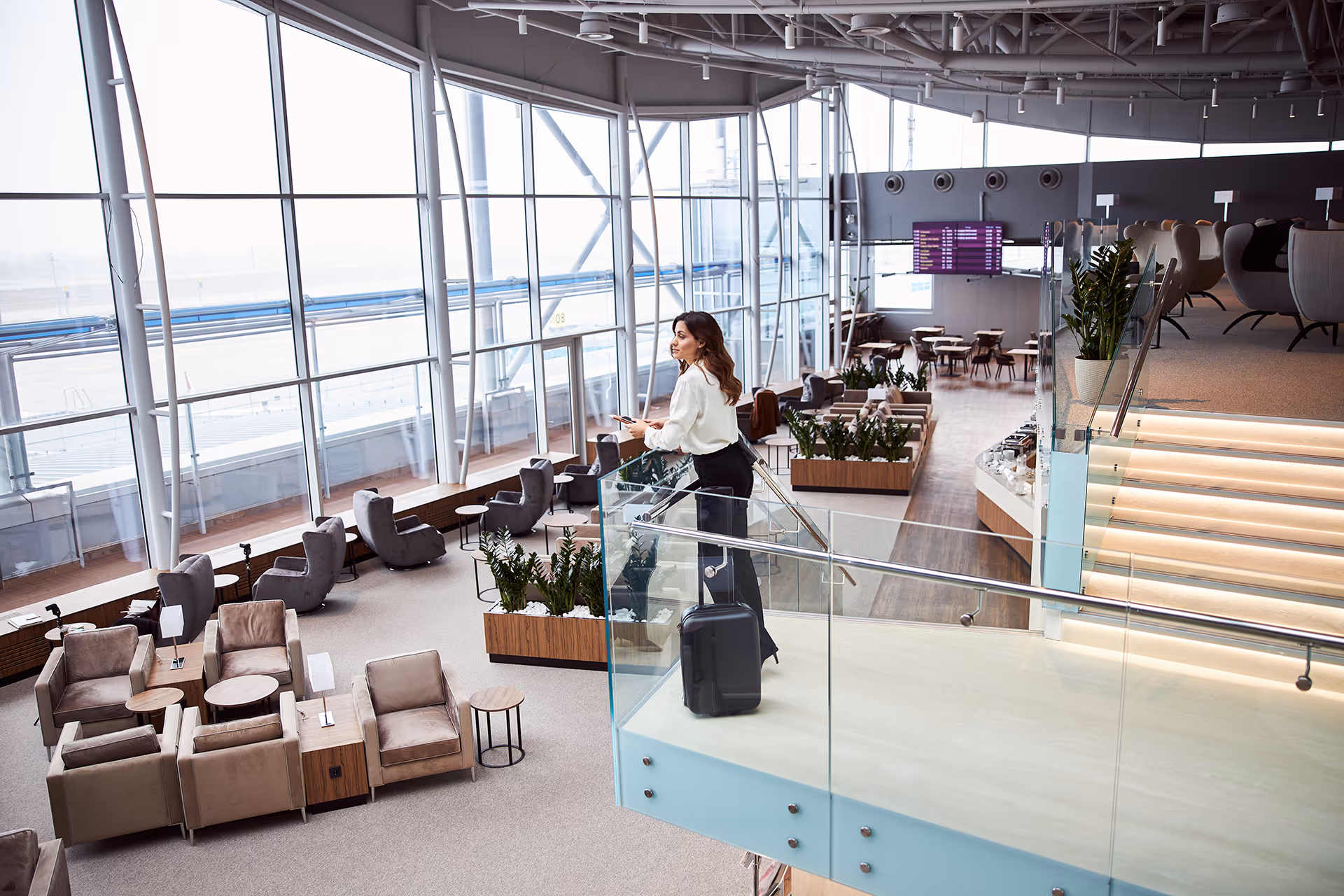 Woman waiting in an airport  — representing travel membership club merchant accounts