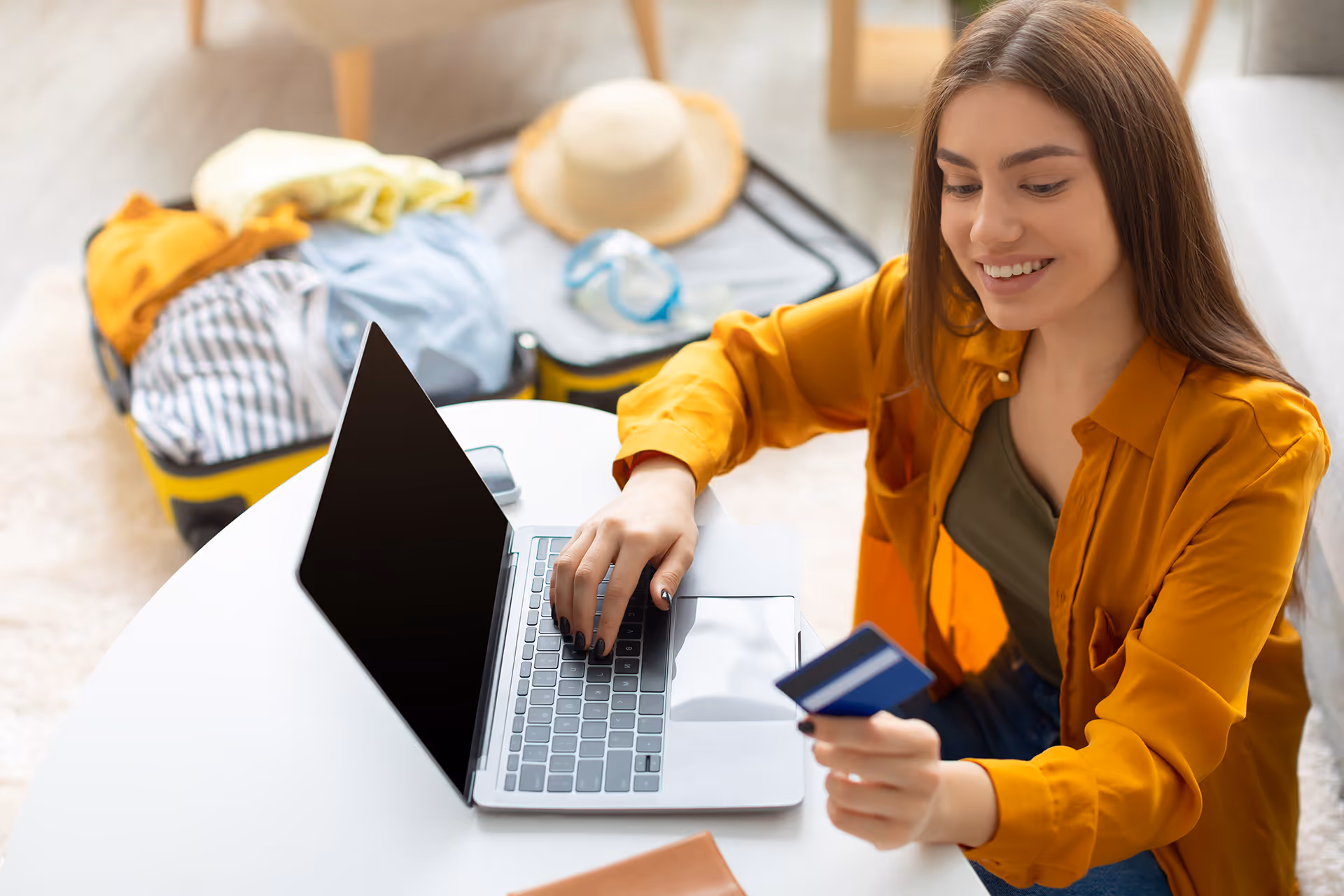Woman holding a debit card and buying a holiday online