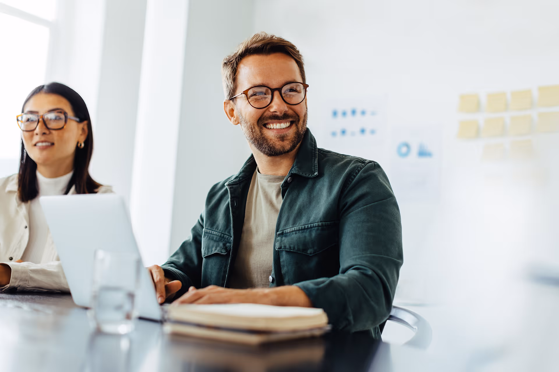 Man smiling sat at a meeting table