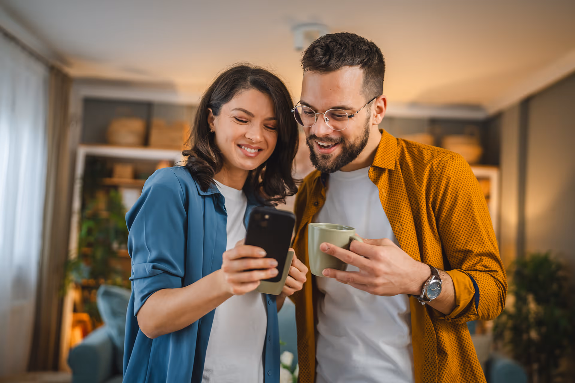 Smiling couple looking at a phone -  — representing travel marketplace merchant accounts