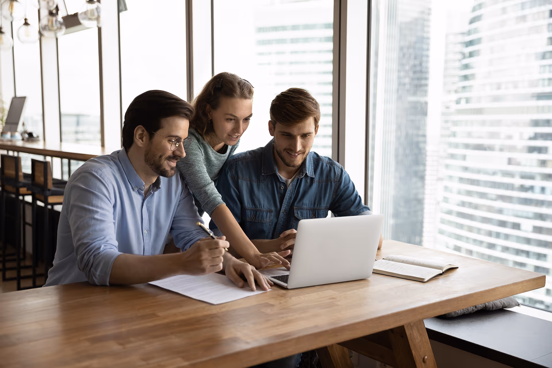 Three people looking at things on a laptop