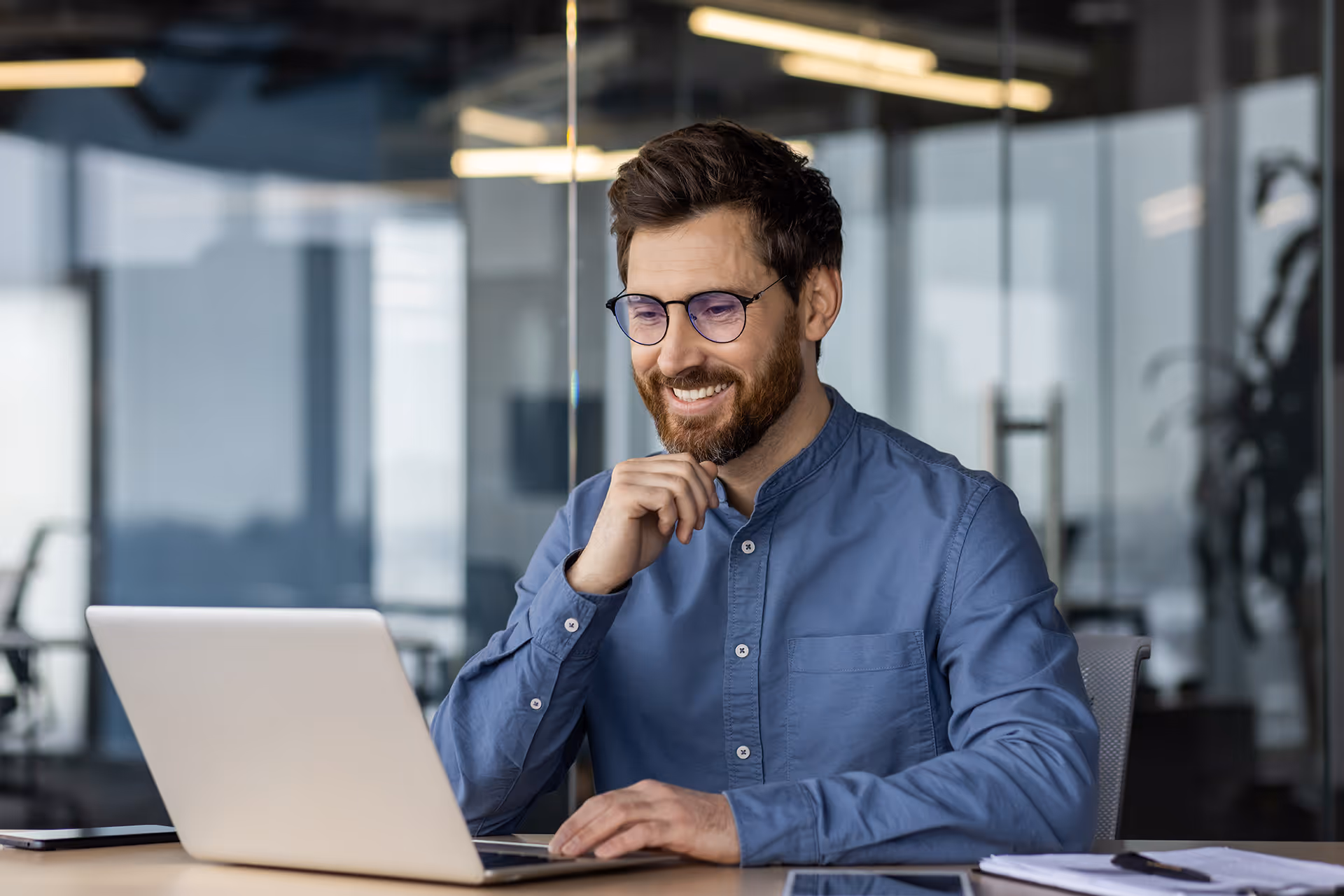 A smiling sat thinking at his work desk