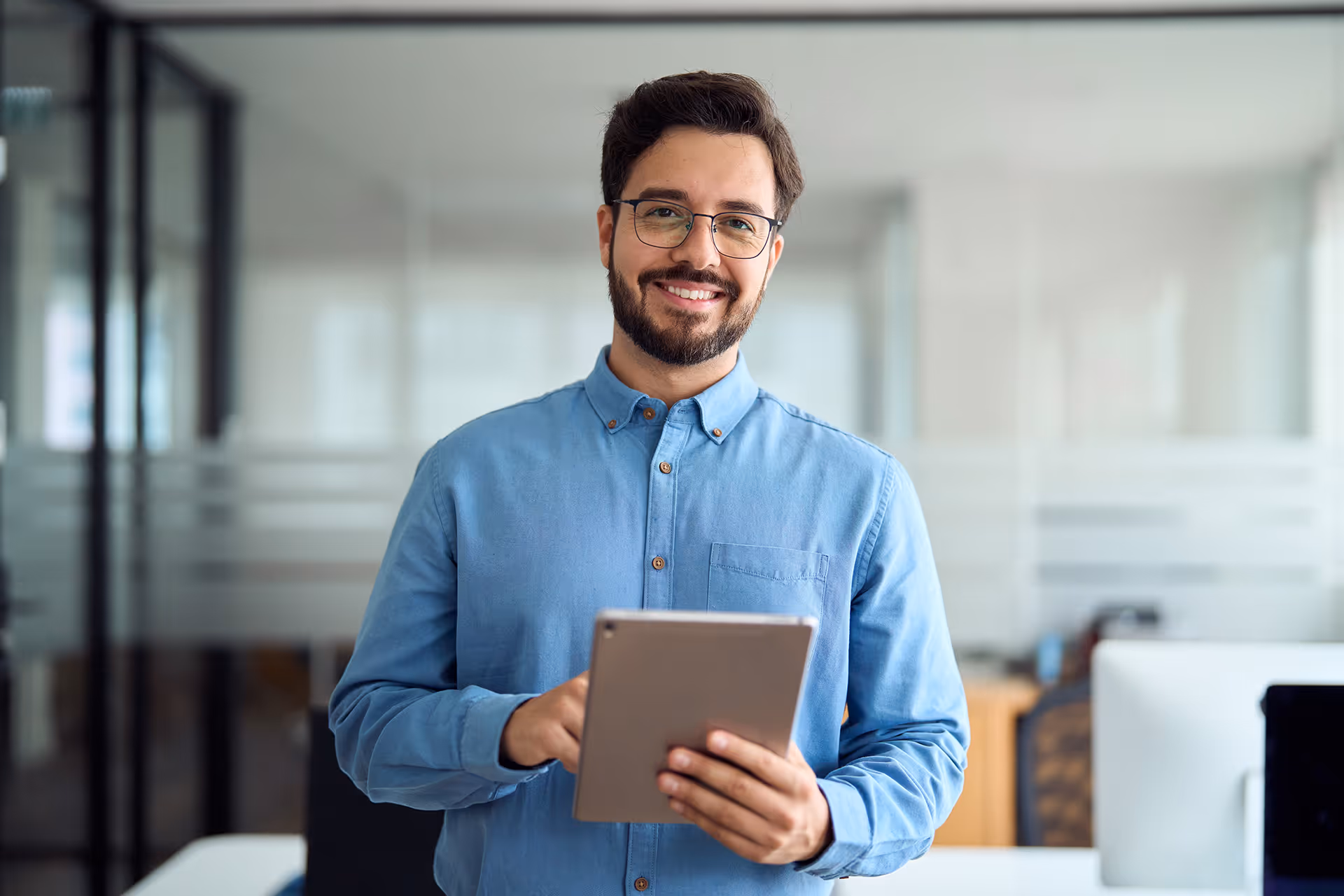 Man smiling with tablet in office