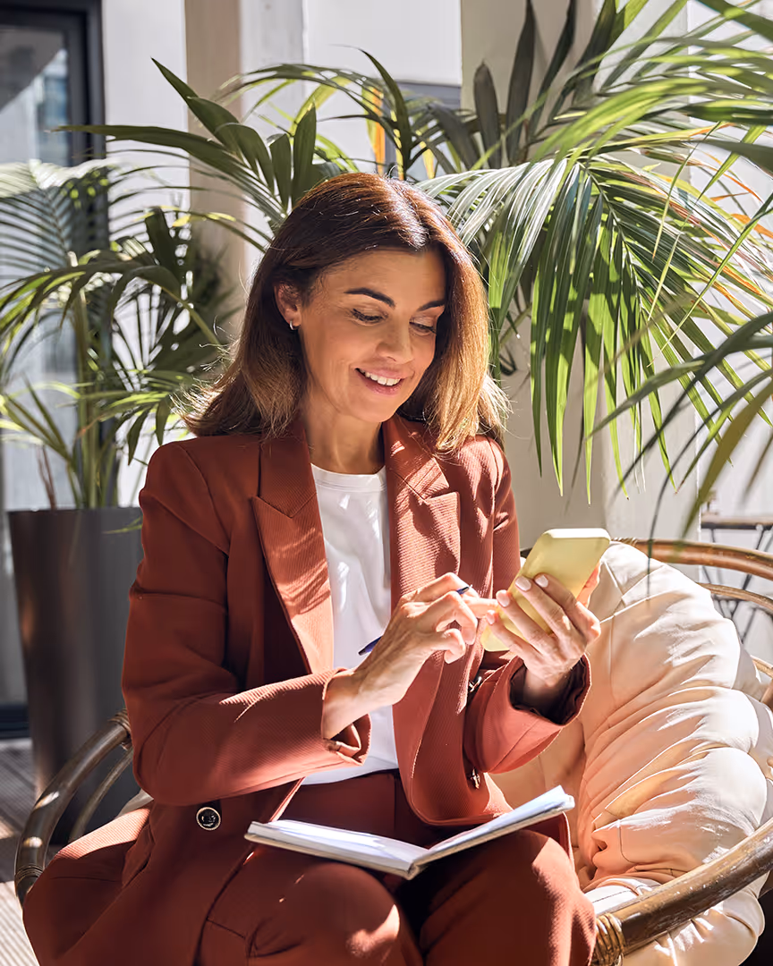 Woman with a notepad using her phone