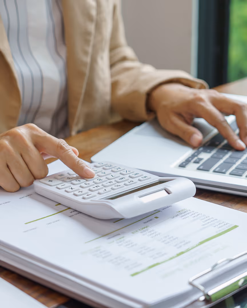 Woman calculating finances using a laptop and calculator
