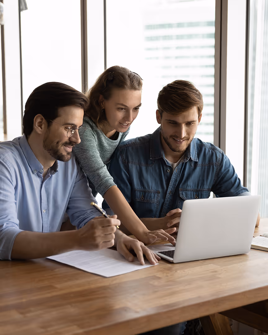 Team looking at laptop and deciding on a merchant account for their accommodation provider business