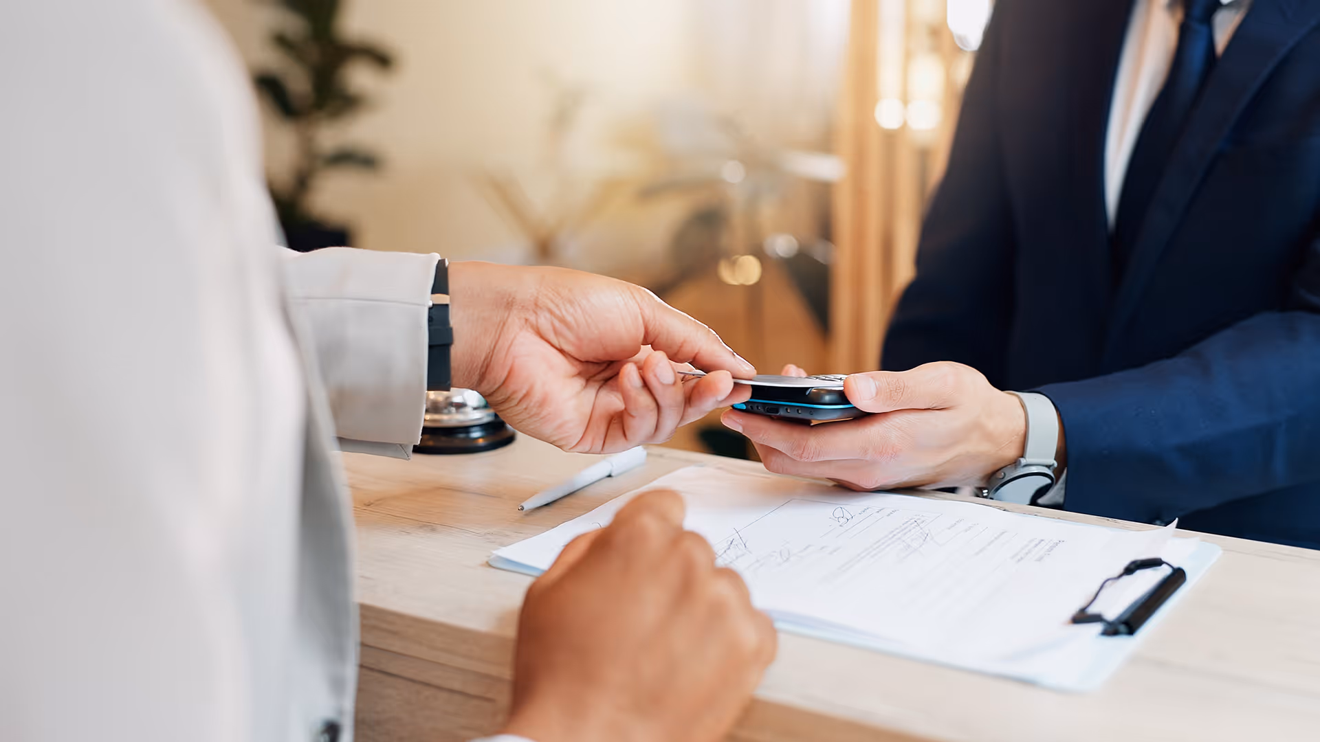 Man making a card payment at a hotel, representing travel merchant accounts