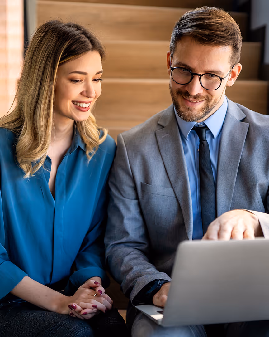 Business partners on a laptop exploring Repayd's travel specific merchant account features