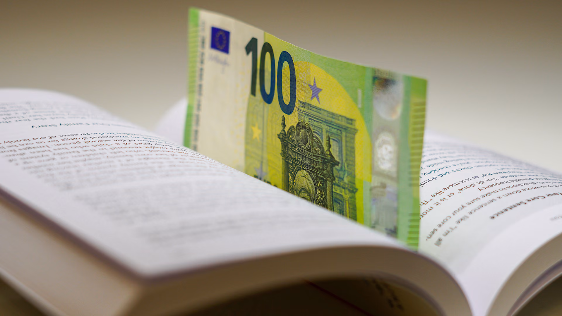 A hundred euro note in a book, representing the payment industry glossary
