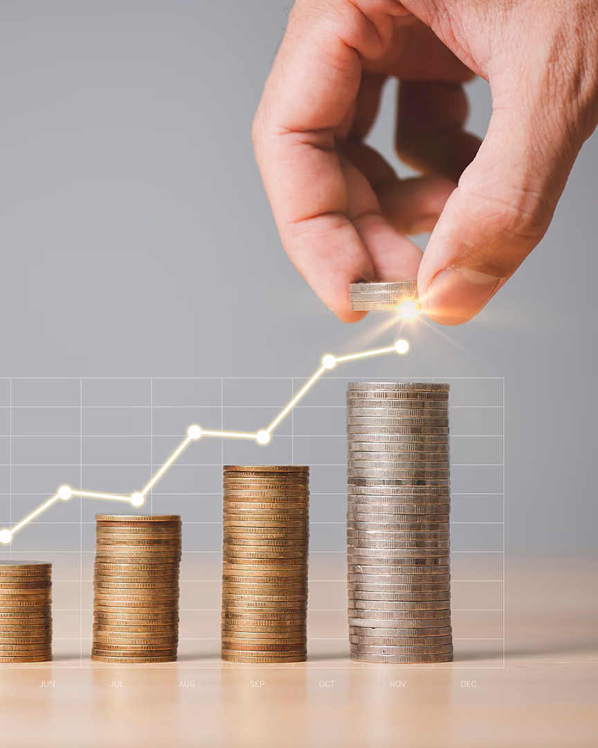 Stacks of coins beneath an upward trending line graph, representing merchant account stability and growth