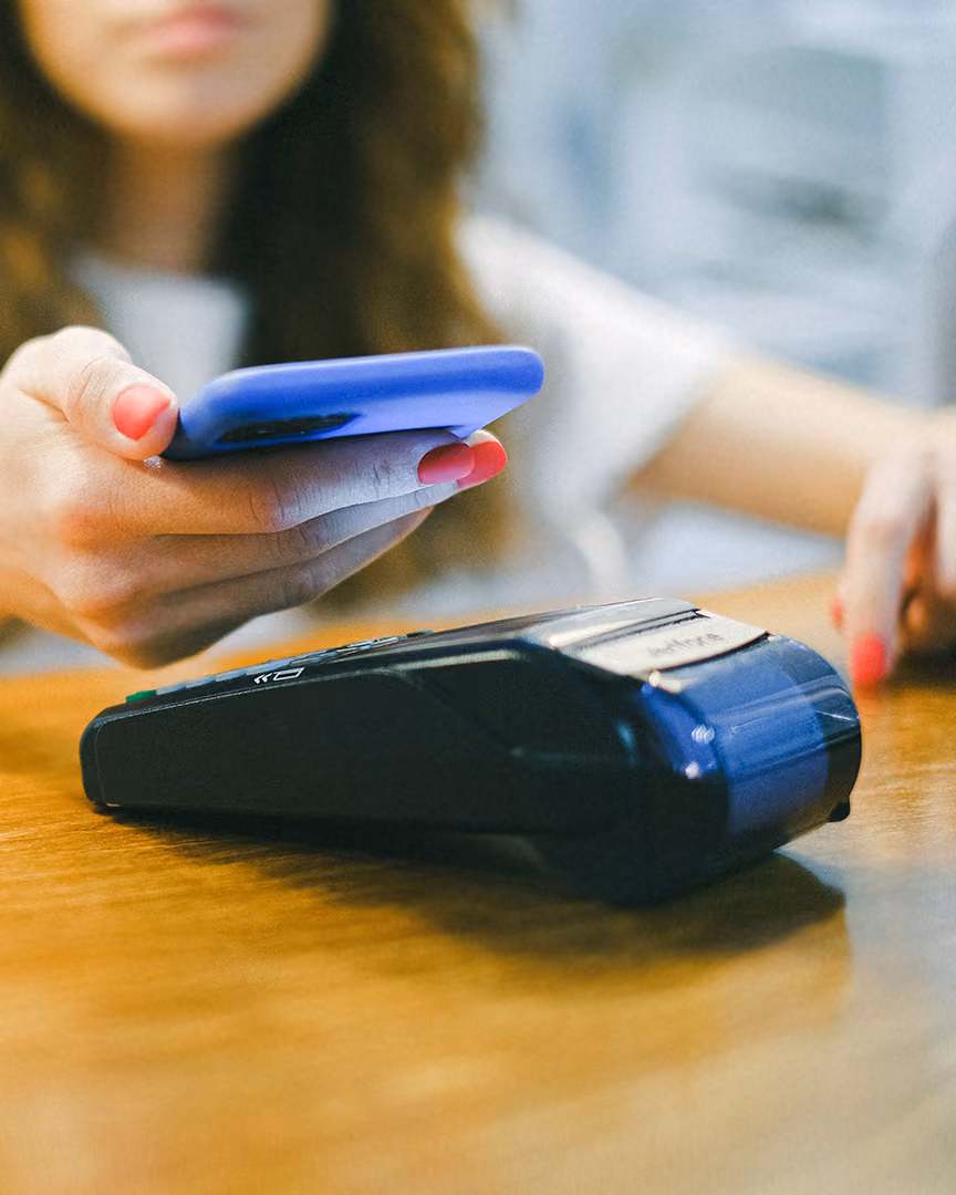 Woman making a contactless payment, representing payment processing