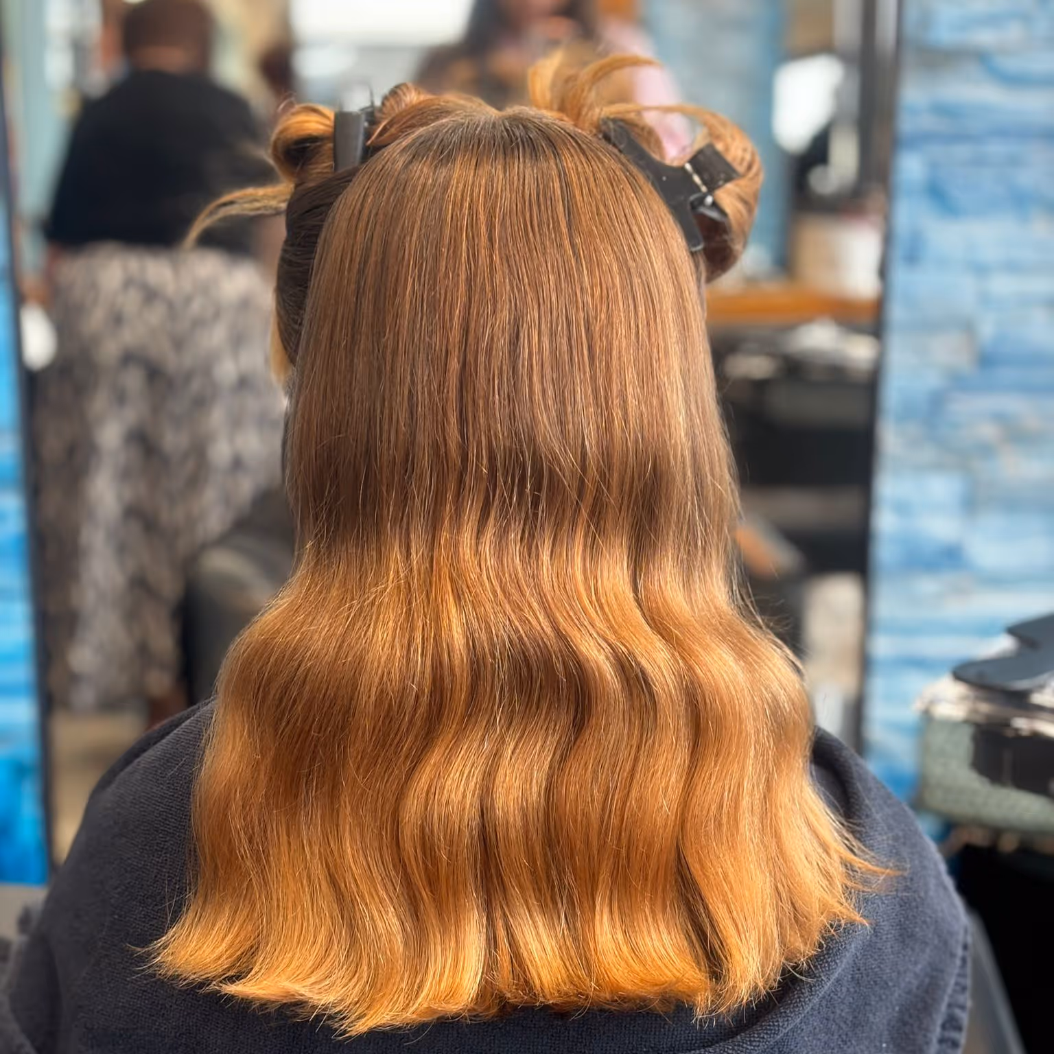 Profil d'un jeune homme avec une coupe de cheveux courte dégradée sur les côtés et des boucles définies sur le dessus.
