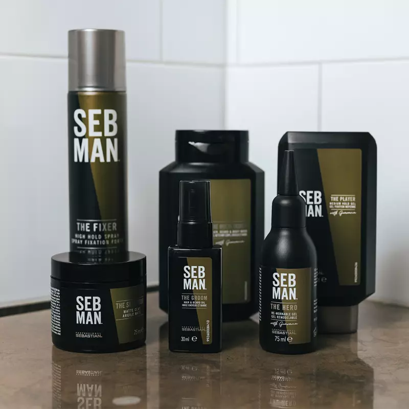 Ensemble de produits coiffants Seb Man, comprenant un spray fixant, une cire mate, une huile pour barbe, un gel remodelable et une pâte coiffante, disposés sur un comptoir.