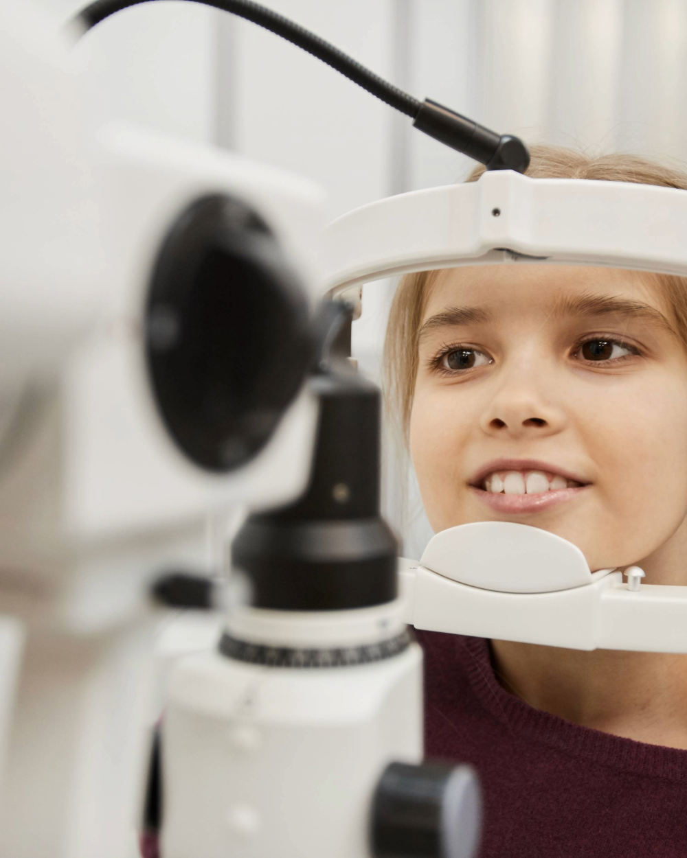 Child getting eye exam with professional optometry equipment