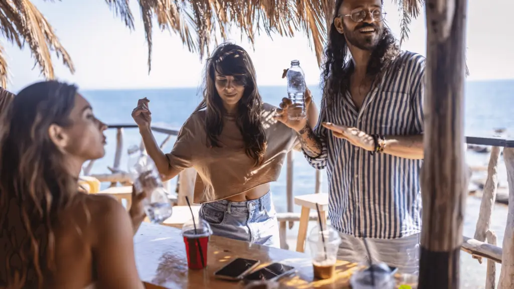 Jeunes employés saisonniers travaillant en extérieur sous une paillote, illustrant le CDD saisonnier dans le tourisme et la restauration