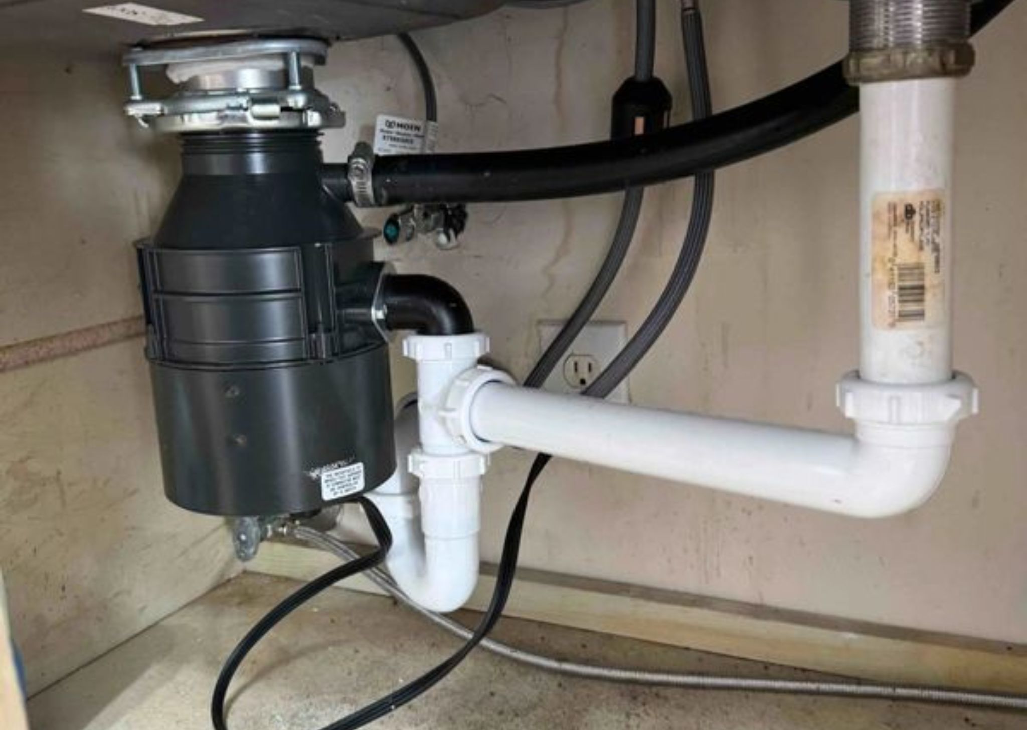 Under-sink garbage disposal installation ensuring efficient food waste removal and proper drainage.