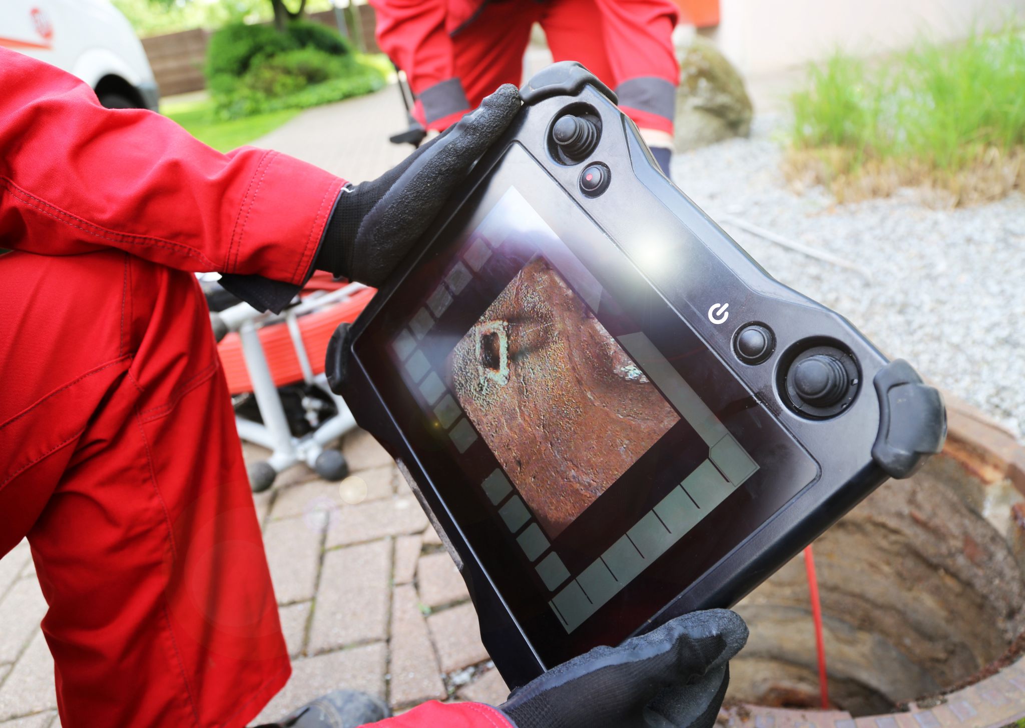 Close-up of a sewer inspection camera screen showing pipe interior damage.
