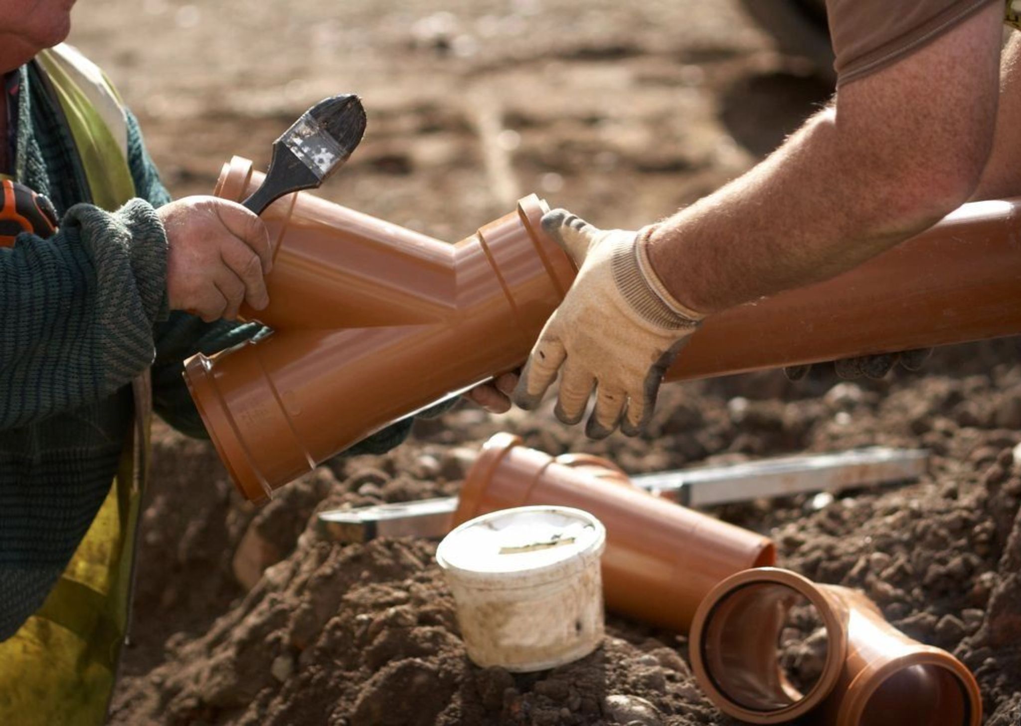 Plumbers connecting underground water line pipes during a main water line repair.
