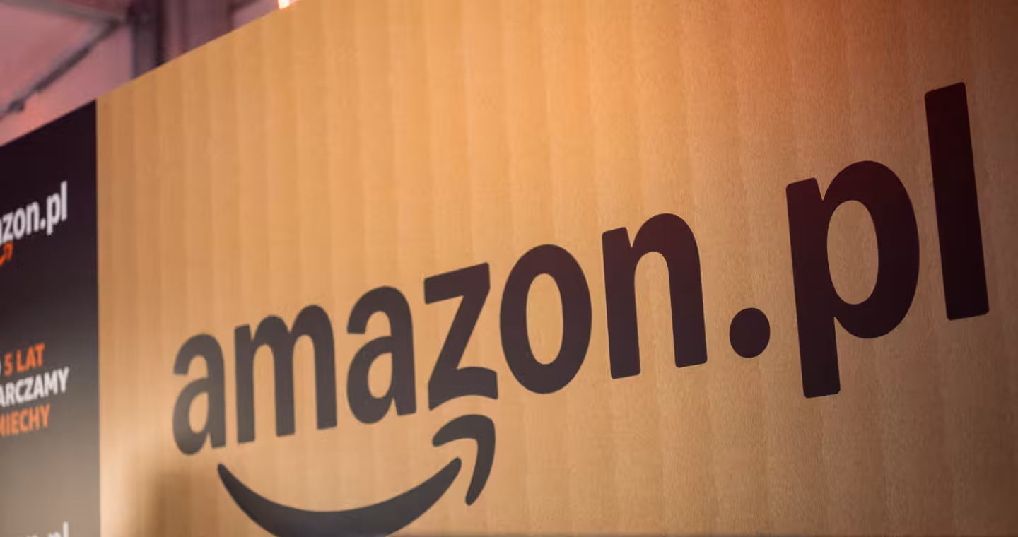 Zbliżenie na logotyp Amazon.pl na tle tekstury kartonu transportowego podczas jubileuszu 5 lat obecności marki na polskim rynku.