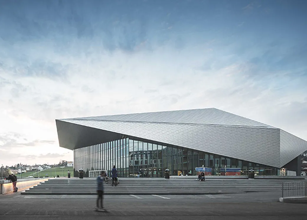 Futuristic building with a glass facade and angular design.