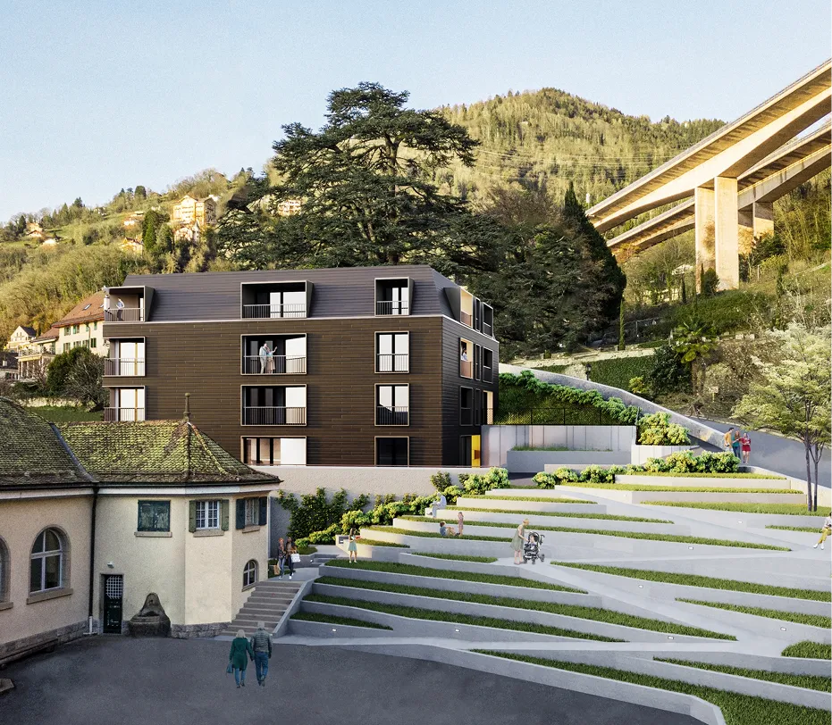 Immeuble résidentiel contemporain entouré d’espaces verts en terrasses, avec une vue sur la montagne et un viaduc à l’arrière-plan.
