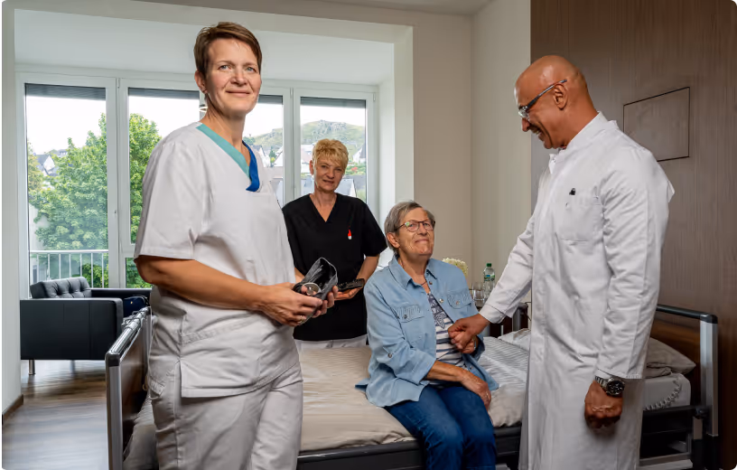 Pflegekräfte und Arzt im Patientenzimmer des Krankenhauses Maria Hilf Warstein – persönliche Betreuung und medizinische Fürsorge.