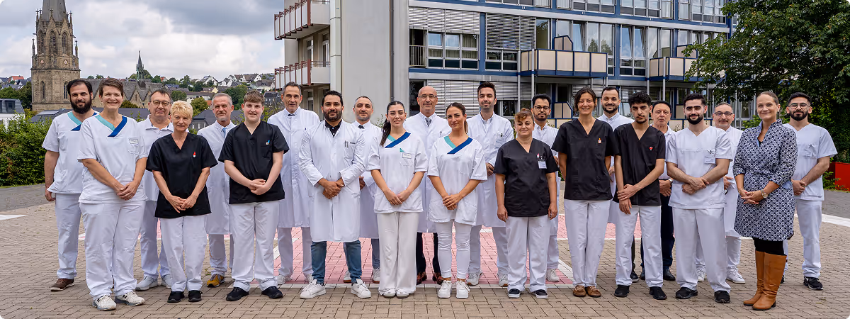 Gesamtes Team des Krankenhauses Maria Hilf Warstein – interdisziplinäre Fachkräfte vor dem Klinikgebäude im Herzen von Warstein.