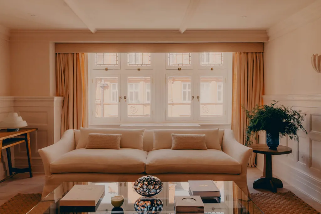 The Mount Street reception, with a linen sofa beneath tall windows.