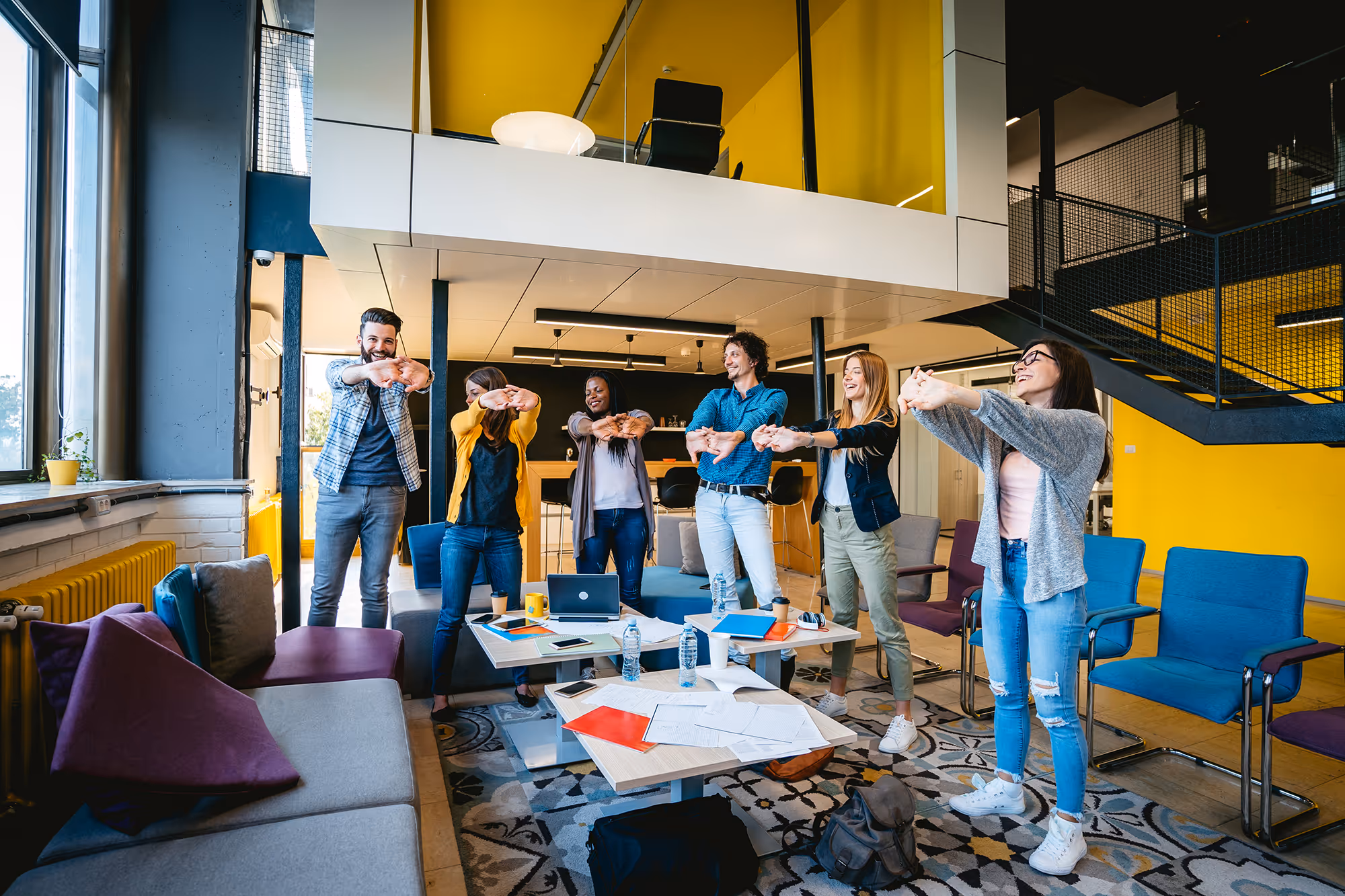Sechs Mitarbeiter:innen beim Stretching im Büro