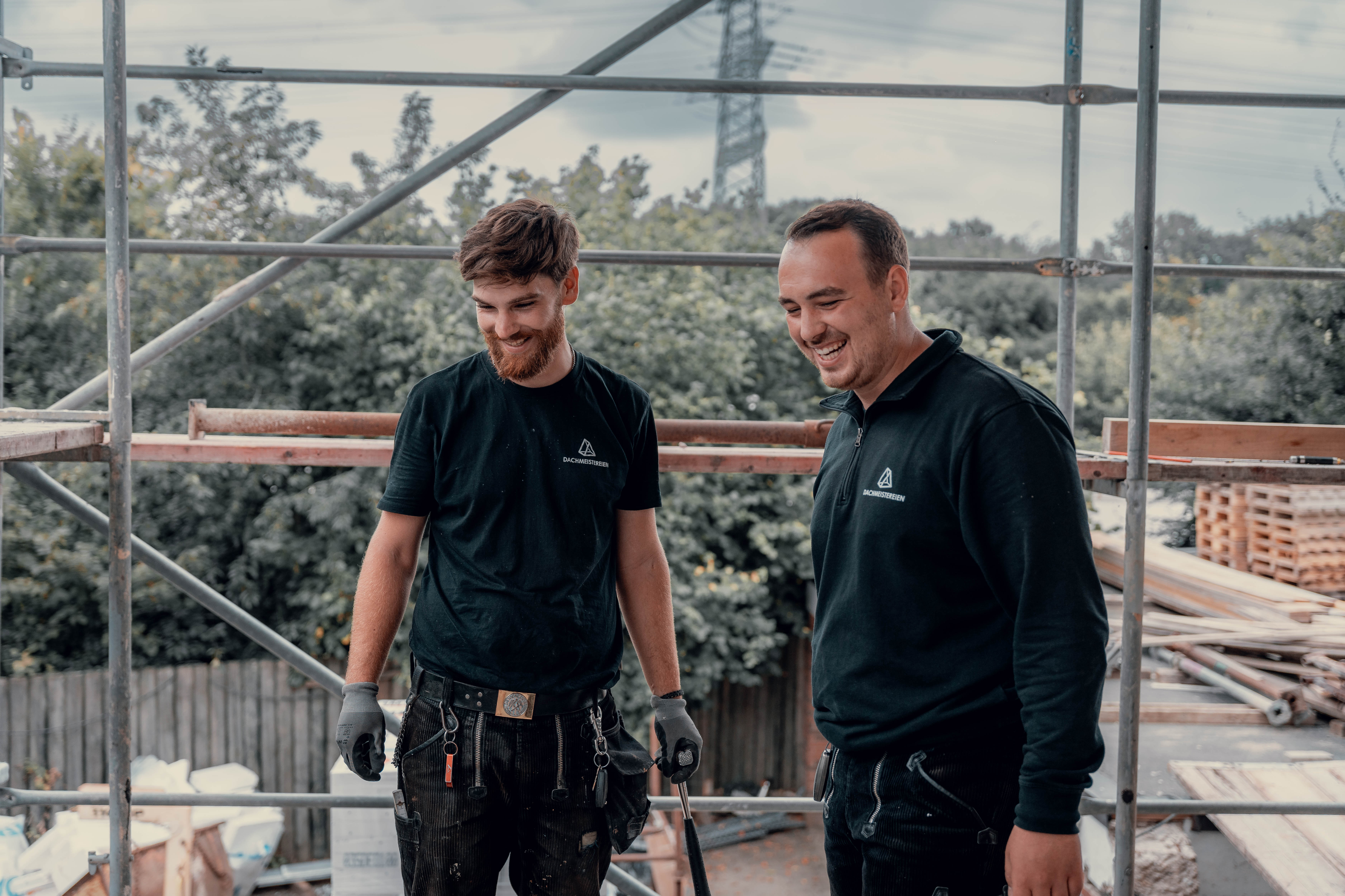 Dachdeckermeister Nino Ellis und sein Vorarbeiter bei der Arbeit auf einer Baustelle – Dacharbeiten mit Qualität und Erfahrung.“