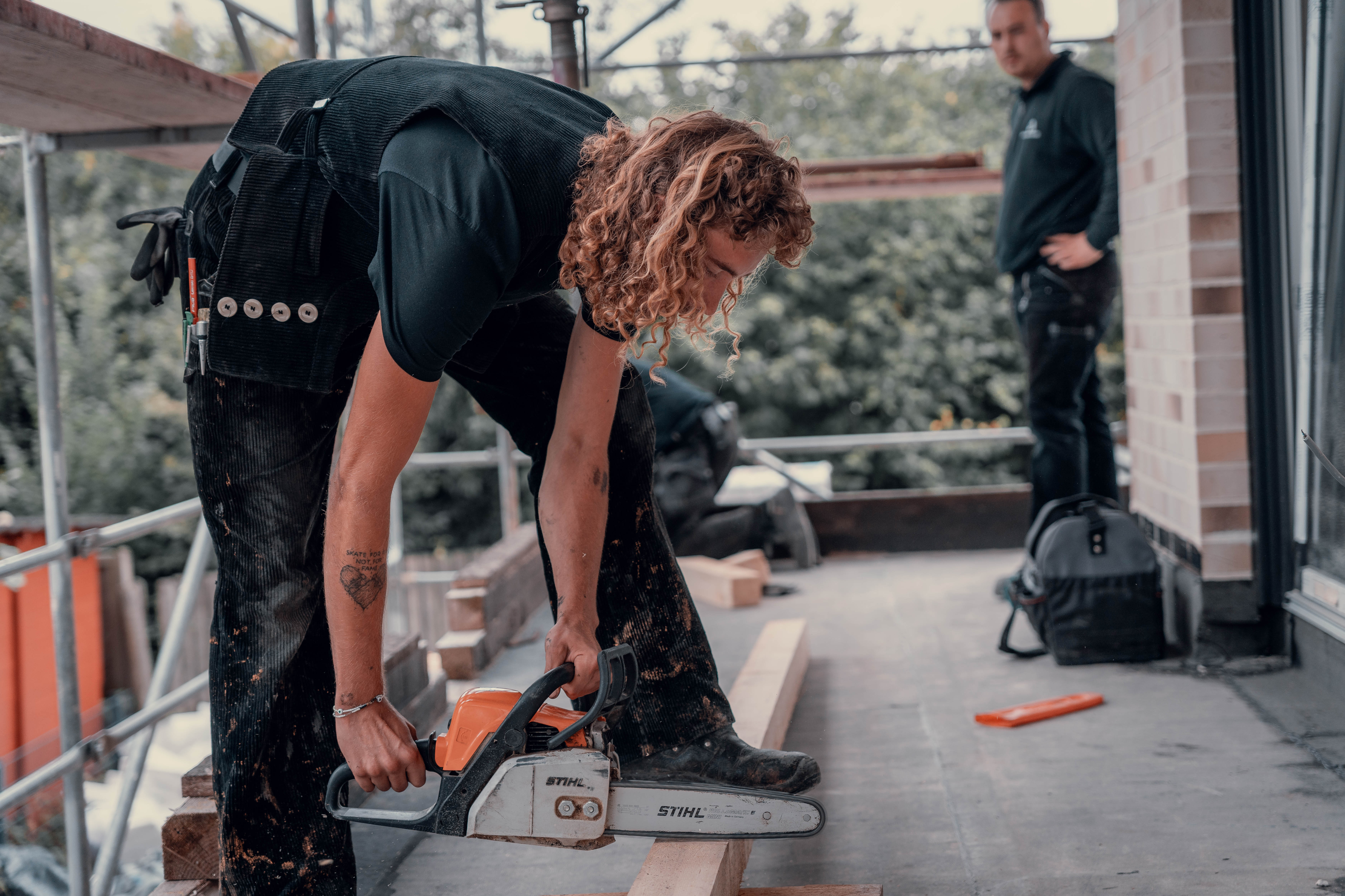 Mitarbeiter der Dachmeistereien bei professionellen Sägearbeiten auf einer Baustelle.