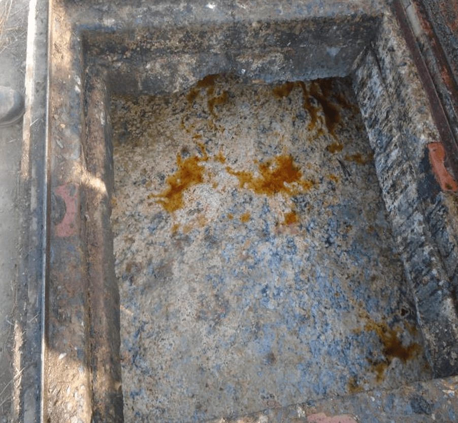 Before: thick surface grease and hardened FOG line the trap walls, with strong odor and solids that rebuild within days of every cleanout.