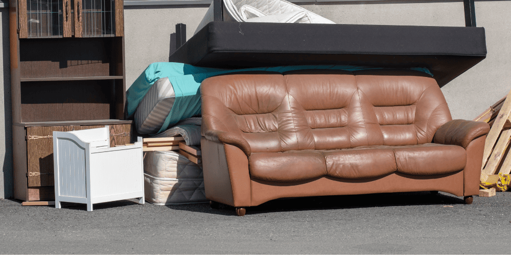 Junk removal team lifting a couch from a Hyde Park basement