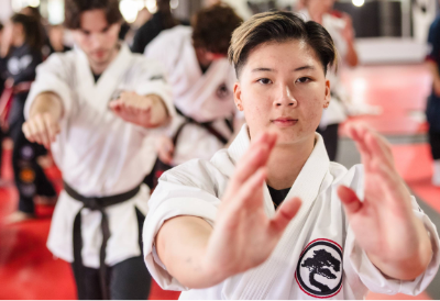 A woman in a karate gi participating in forms during a karate class
